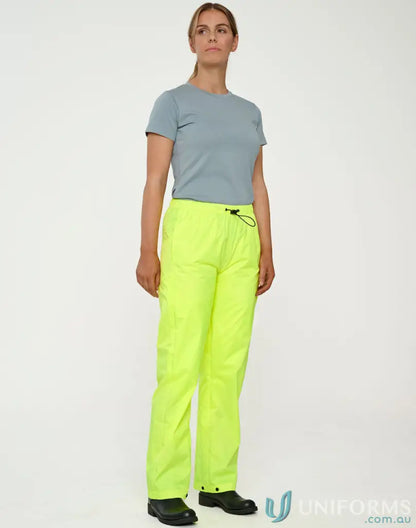 Woman wearing bright yellow lightweight nylon waterproof rain pants for rainy days