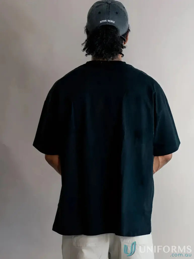 Black luxe oversized tee with subtle center split perfect for comfortable workwear and modern uniforms