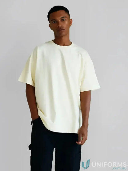 Man in a cream oversized tee and black pants, perfect for casual uniforms styling