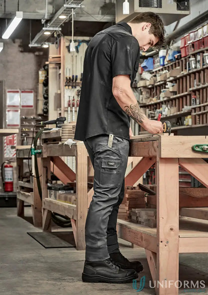 Man wearing black short-sleeved work shirt and dark gray stretch cargo pants