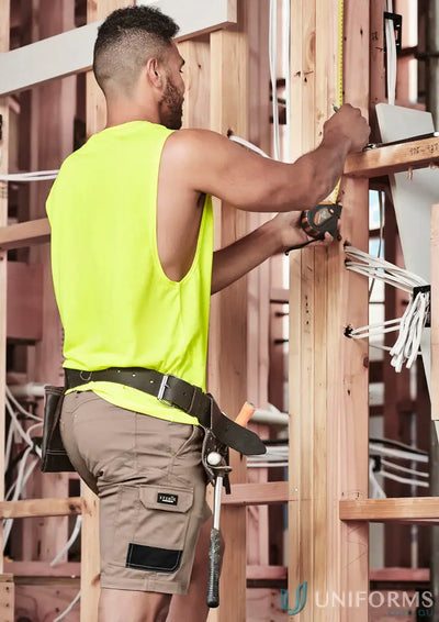 Construction worker measuring wood frame in mens summer cargo shorts for comfort and style