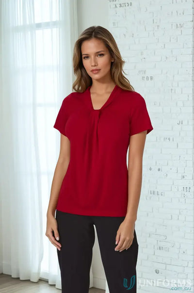 Woman in red top with soft draped neckline and comfortable fit in Pippa Ladies SS Top