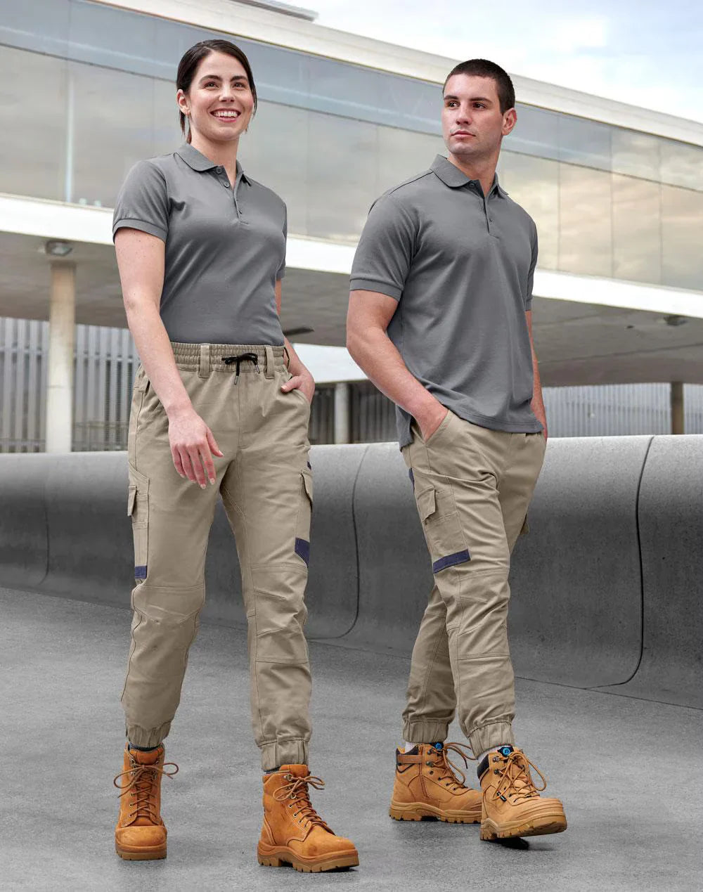 Two people in gray polo shirts wearing PLANETT unisex cotton stretch cuffed work pants