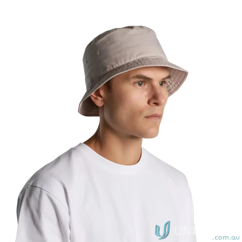 Man in a light beige bucket hat with reinforced brim and eyelets, perfect for sunny days