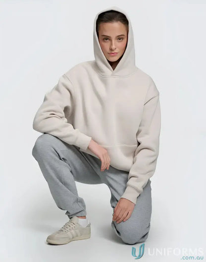 Woman in beige fleece hoodie CVC and gray sweatpants showcasing our oversized fleece hoodie