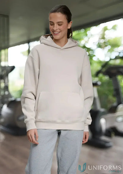Woman wearing a beige recycled polyester premium fleece oversized hoodie and gray sweatpants