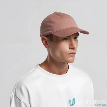 Man wearing a dusty rose baseball cap with adjustable metal clasp and white t-shirt
