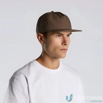 Man wearing a white T-shirt and brown flat peak cotton canvas cap with plastic snapback