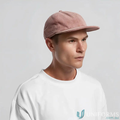 Man wearing a pink unstructured six-panel cap with 8-wale partridge cord and adjustable metal clasp