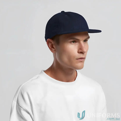 Man wearing navy blue flat-brim cap with adjustable metal clasp and tonal under-peak lining