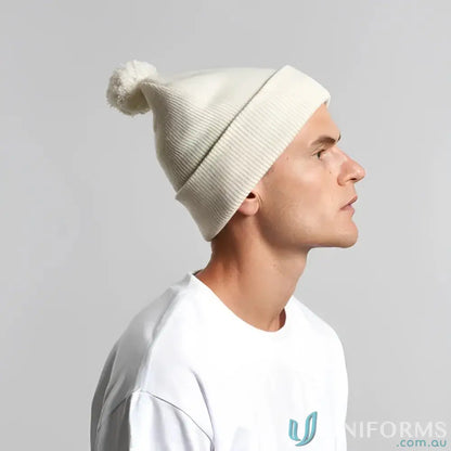 Man wearing a cream recycled acrylic pom pom beanie for winter warmth