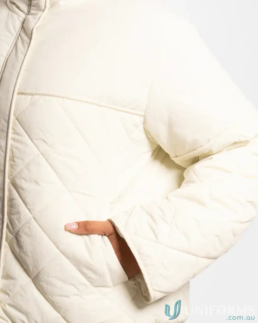 Cream-colored quilted puffer jacket with internal zip pocket and high stand-up collar
