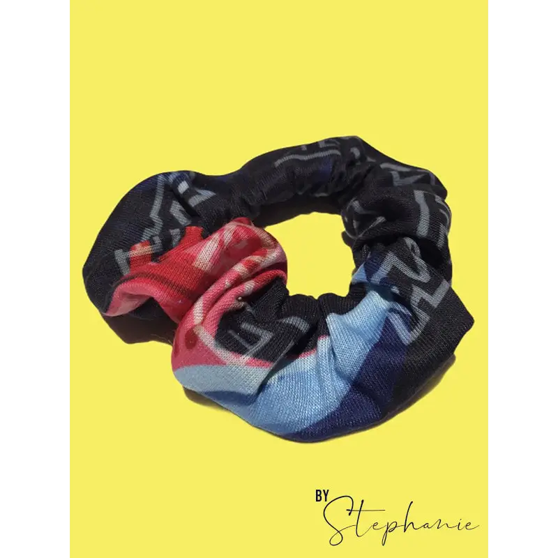 A black rainbow scrunchie with a bold red blue and gray geometric pattern perfect for workwear or uniforms