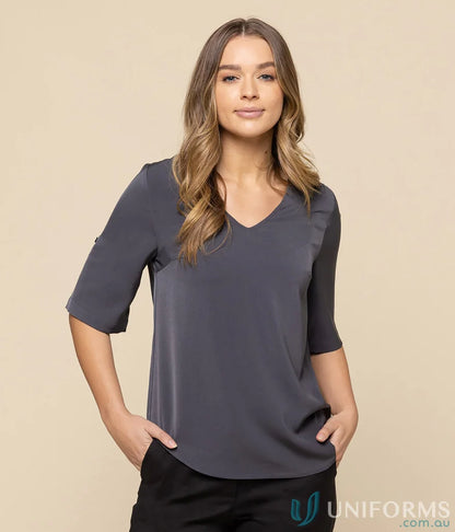 Woman in gray Reese V-Neck Top, perfect workwear for uniforms and stylish looks