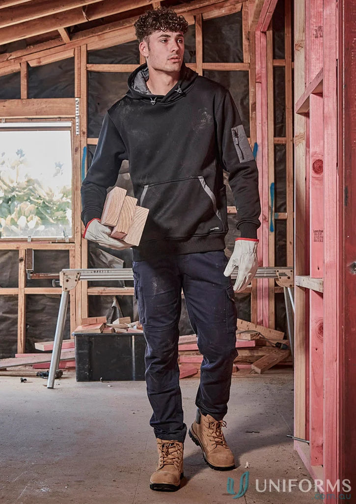 Man in rugged cooling stretch workwear pants holding wood, showing durability and ripstop construction