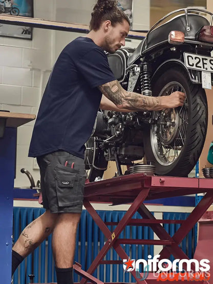 Man fixing a motorcycle in rugged cooling stretch shorts perfect for sun protection