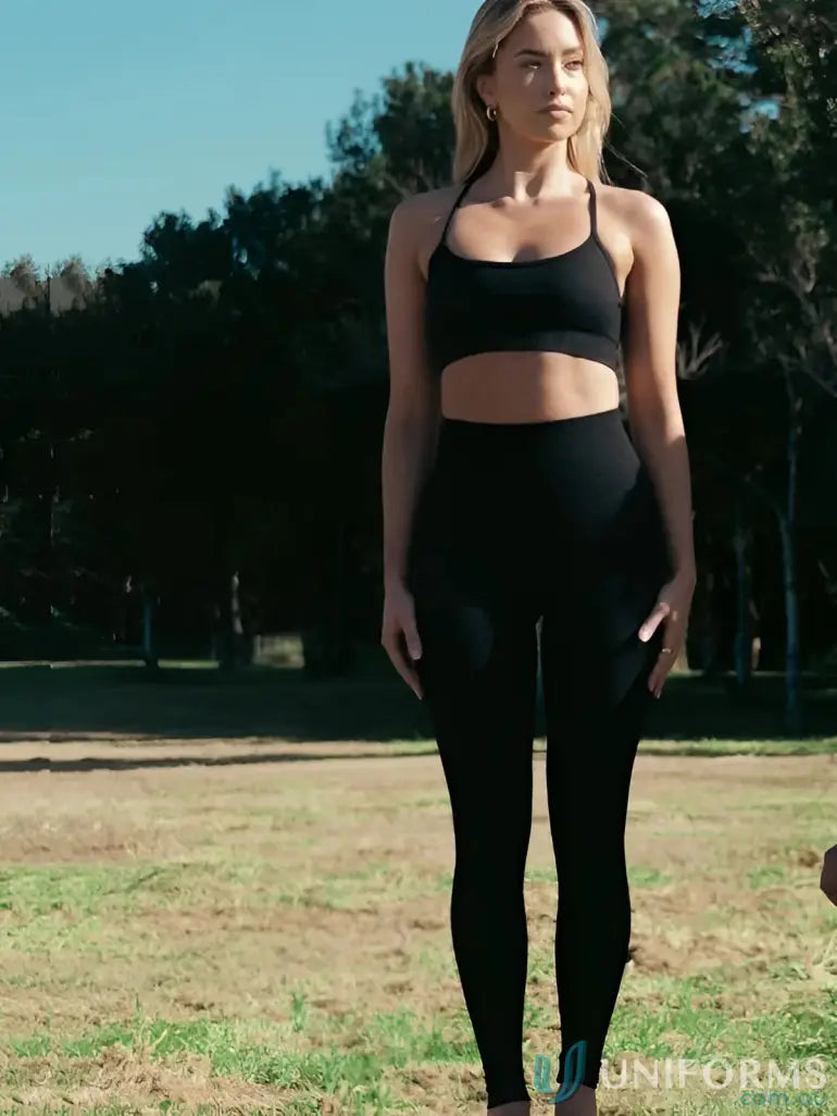 Woman in black athletic wear showcasing Seamless Invicible Scrunch Onyx Leggings, perfect for work uniforms