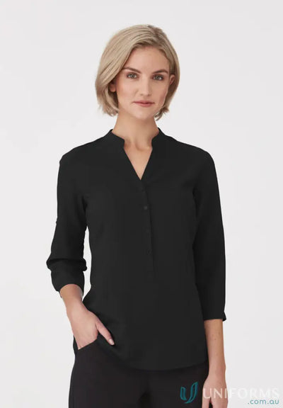 Woman wearing SoEzy Top black long-sleeved workwear tunic with rolled-up sleeves