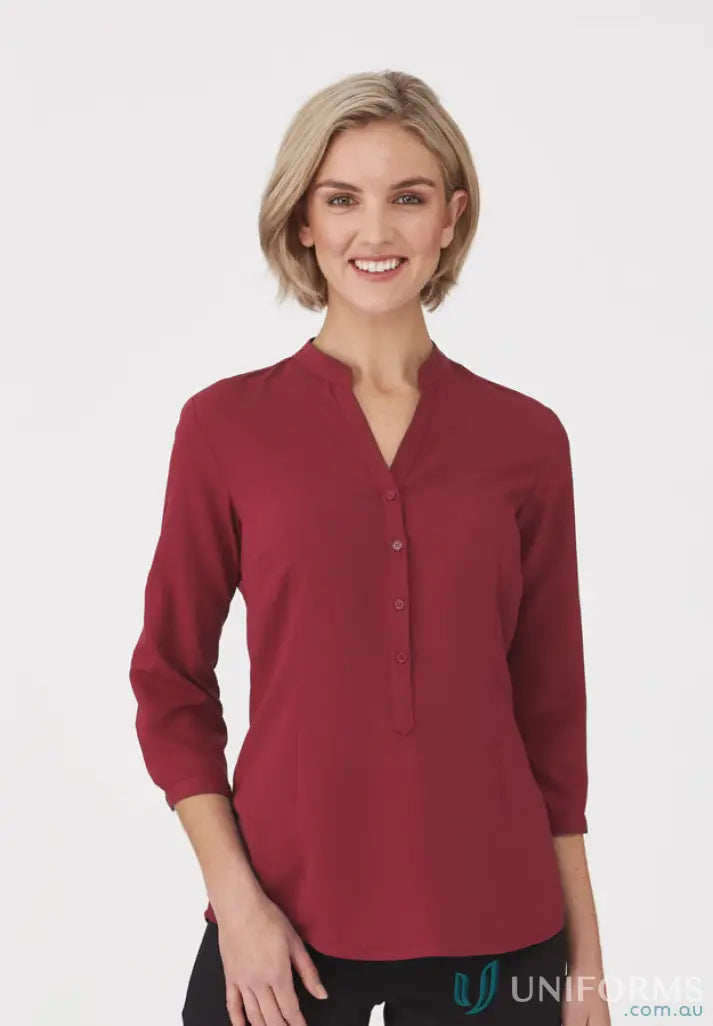 Smiling woman in red SoEzy Top workwear, perfect for work uniforms and uniforms