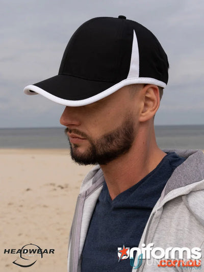 Black and white baseball cap on a man at the beach, perfect for sports or workwear