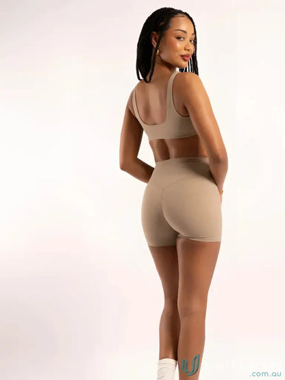 Tan athletic shorts and top set with square neckline, perfect for workout uniforms