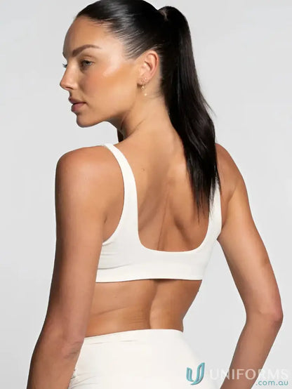 Woman in white sports bra with square neck, perfect for stylish uniforms