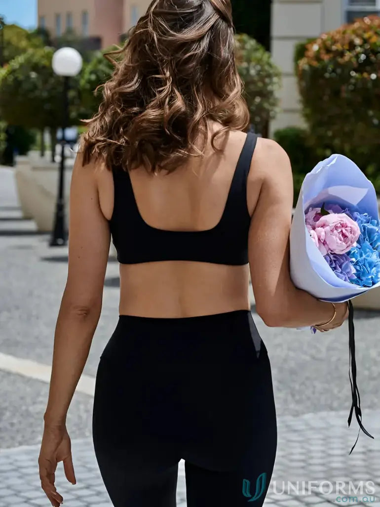 Woman in black athletic wear with square neck holding flowers, perfect for uniforms