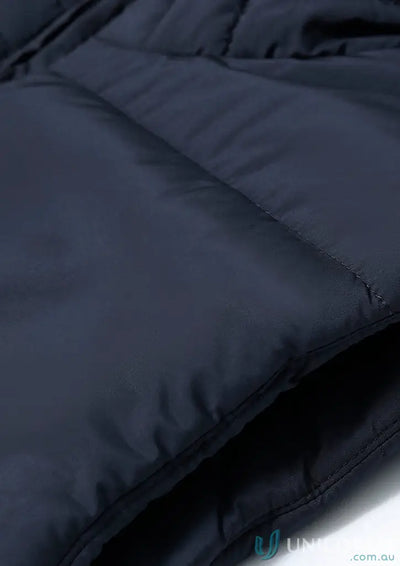 Close-up of a dark blue sustainable insulated puffer vest made from recycled PET bottles
