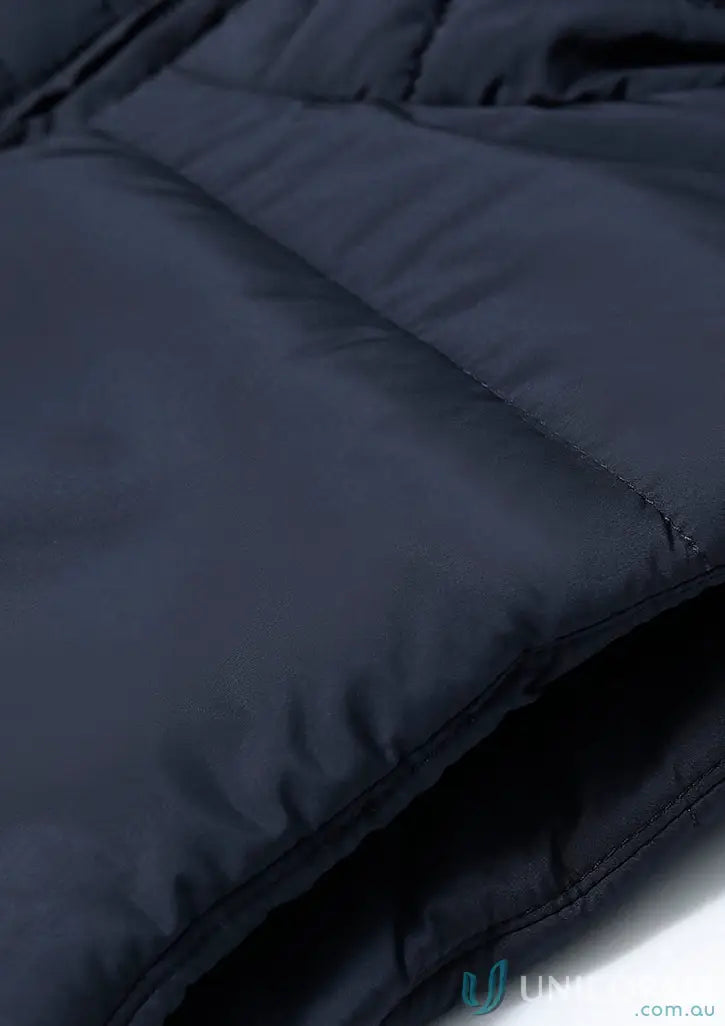 Close-up of a dark blue sustainable insulated puffer vest made from recycled PET bottles