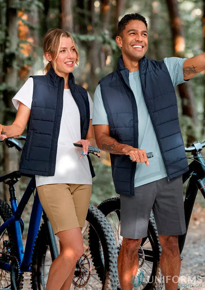 Two people in navy blue sustainable insulated puffer vests with bicycles, made from recycled PET bottles