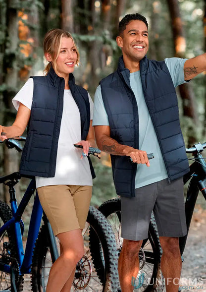 Two people in navy blue sustainable insulated puffer vests with bicycles, made from recycled PET bottles
