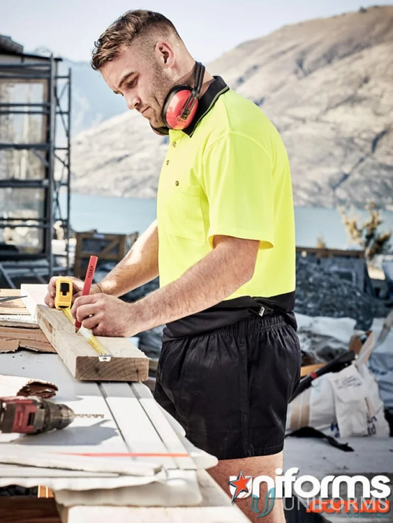 Construction worker measuring wood wearing Syzipik men’s rugby shorts zs105