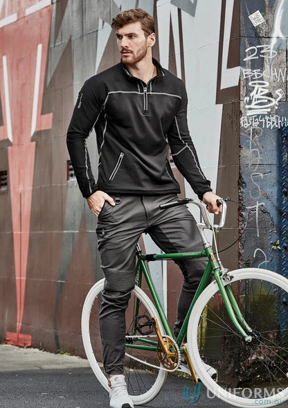 Man in black Syzmik Men’s Streetworx Stretch Pant with stretch pleating and bicycle