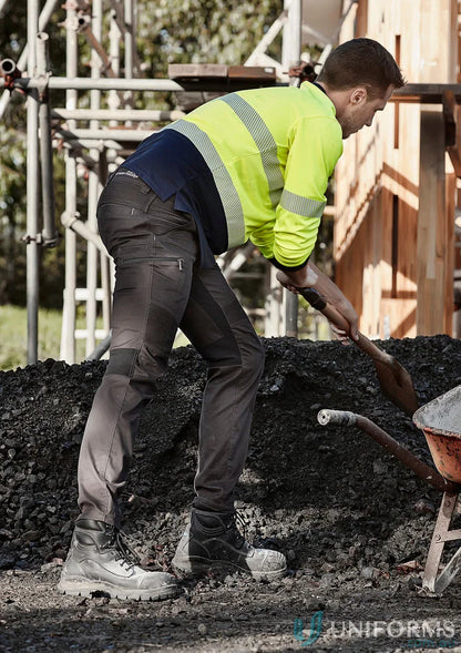 Construction worker shoveling gravel in Syzmic Streetworx Stretch Pants, modern slim fit men’s streetwear
