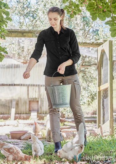 Woman feeding chickens in Syzmik Women’s Lightweight LS Tradie Shirt with feminine fit