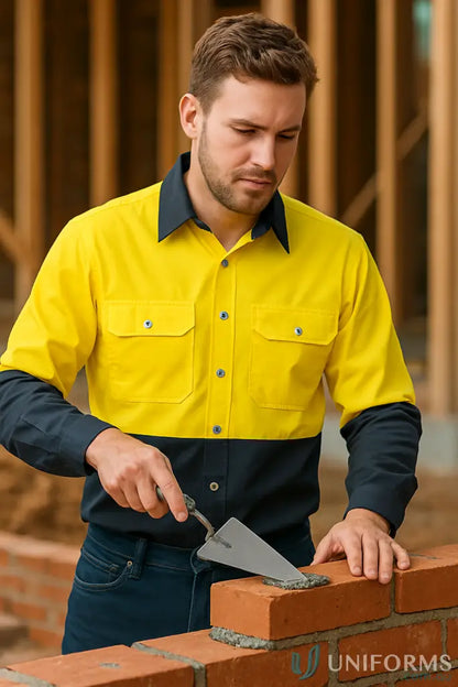 Man wearing Syzmik HiVis Industrial LS Shirt zw122 laying bricks in demanding work environments