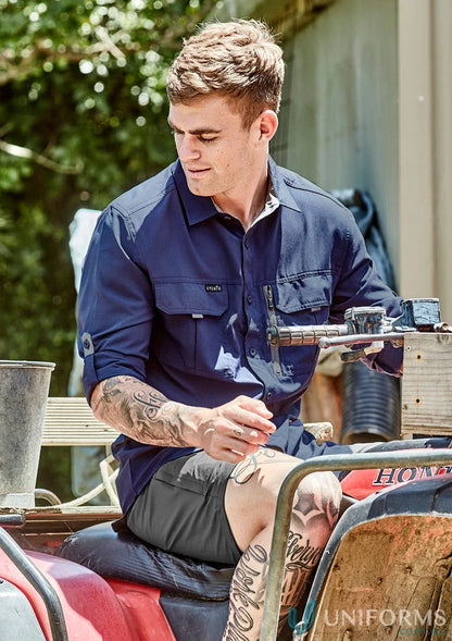 Man in work shirt on ATV wearing Syzmik Outdoor LS Shirt men’s outdoor long sleeve gear