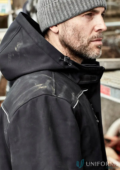 Man in workwear wearing unisex Antarctic Softshell Jacket with storm flap coat