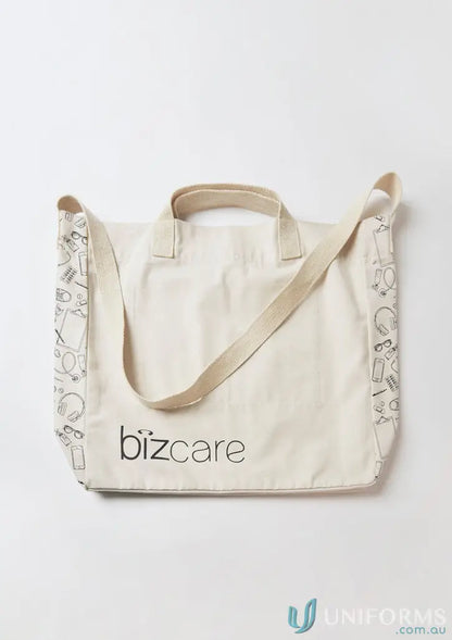 Cream-colored unisex Biz Care Tote Bag with black line art patterns and logo