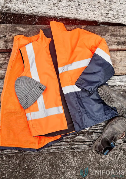 Orange and navy high visibility waterproof reversible vest with grey beanie and work boots
