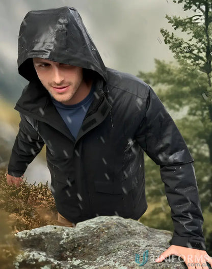 Man climbing rocks in Vic Metro Waterproof Quilted Jacket, perfect for outdoor adventures
