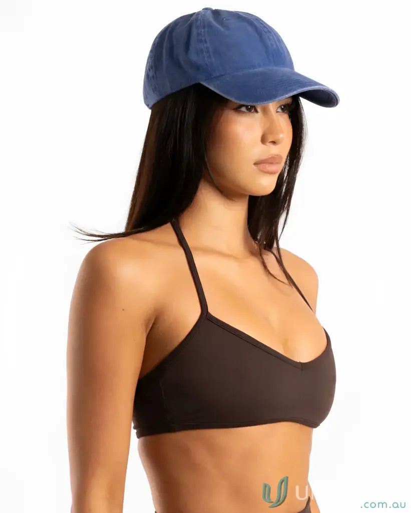 Woman wearing a navy blue washed cotton vintage cap with dark brown bikini top
