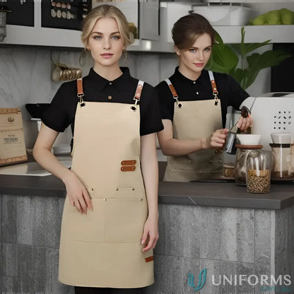 Two women wearing black shirts and beige waterproof canvas kitchen aprons in eight vibrant colours