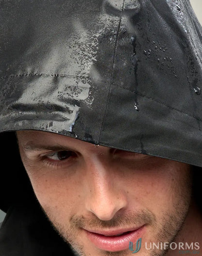 Man in waterproof quilted jacket staying dry in workwear or uniforms outdoors