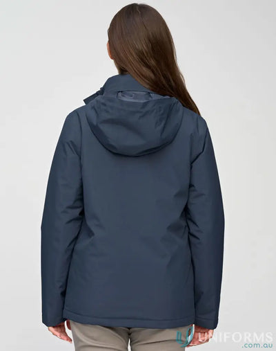 Woman in waterproof quilted jacket and light brown pants staying dry in workwear