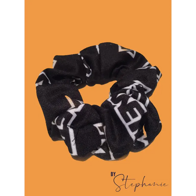 White scrunchie made of black fabric with bold white geometric lettering perfect for uniforms and workwear looks sharp