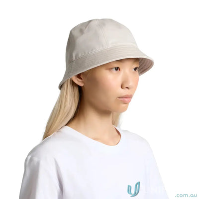 Person wearing a light-colored brim bucket hat with reinforced short brim and white t-shirt