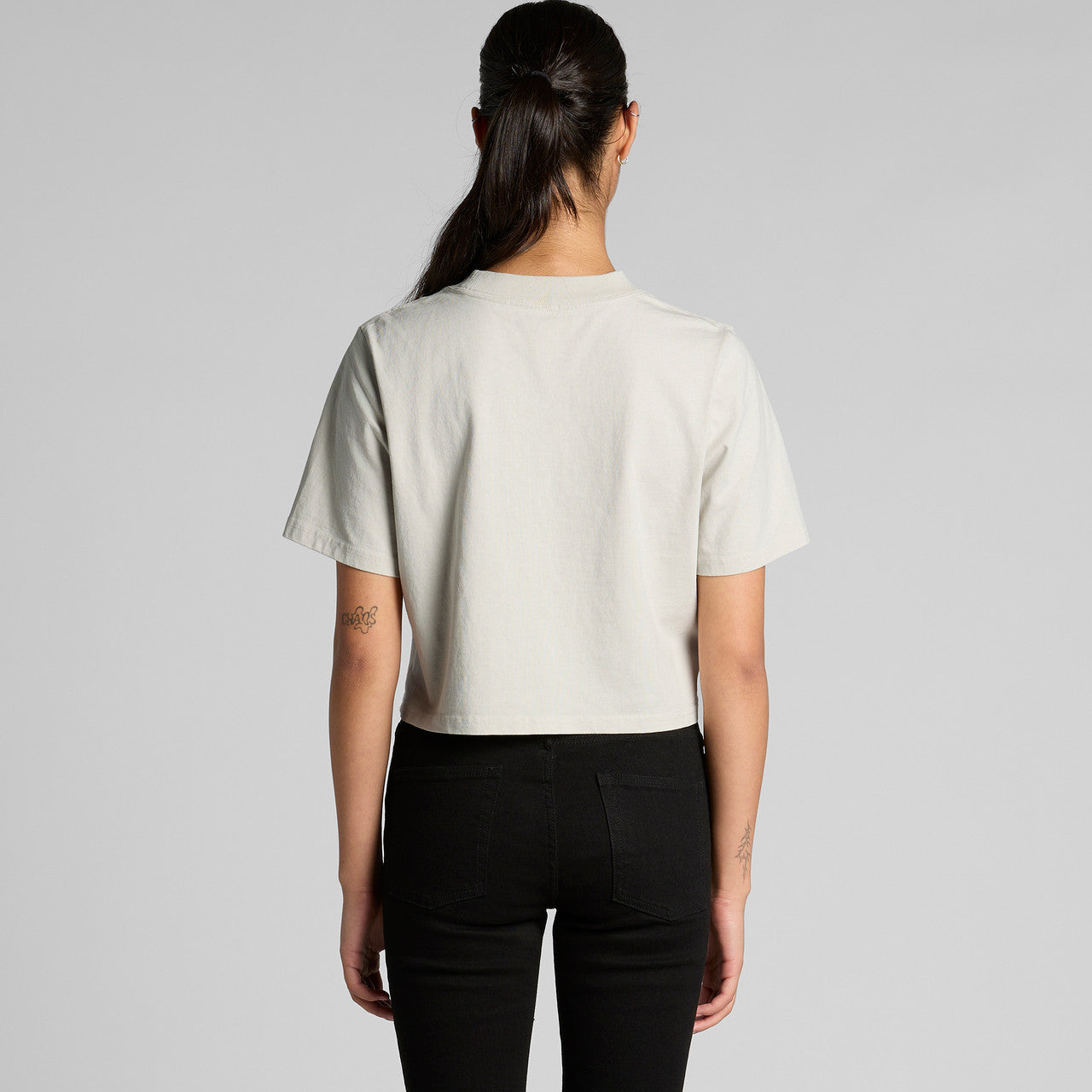 Cream faded crop tee with black pants and ponytail