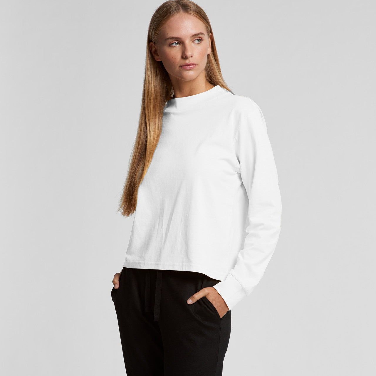 White crew neck sweatshirt with black pants and pockets.