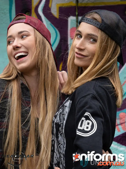 Two women wearing stylish Wood Printed Trucker Mesh Caps with a wide imprint area